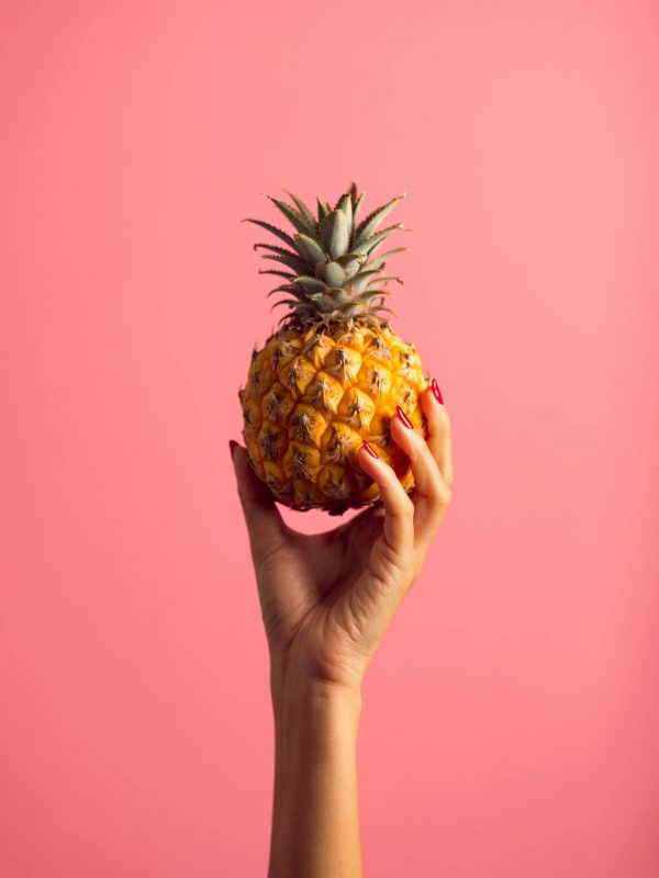 Main-avec-un-ananas Main tenant un petit ananas
